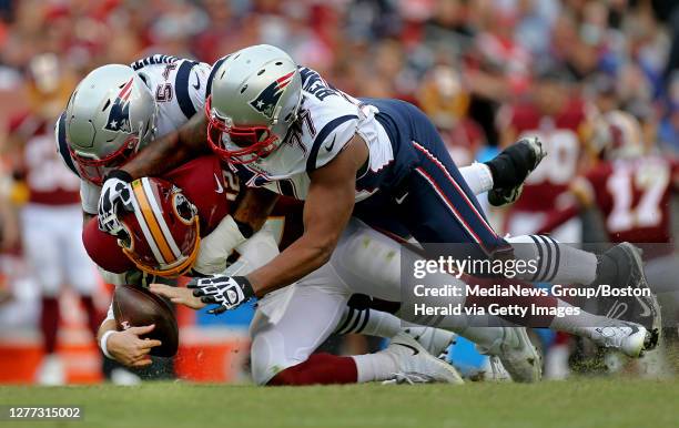Washington Redskins quarterback Colt McCoy is sacked by New England Patriots outside linebacker Dont'a Hightower and defensive end Michael Bennett...