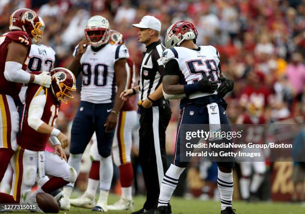 New England Patriots outside linebacker Jamie Collins celebrates sacking Washington Redskins quarterback Colt McCoy who gets a lift up from his...
