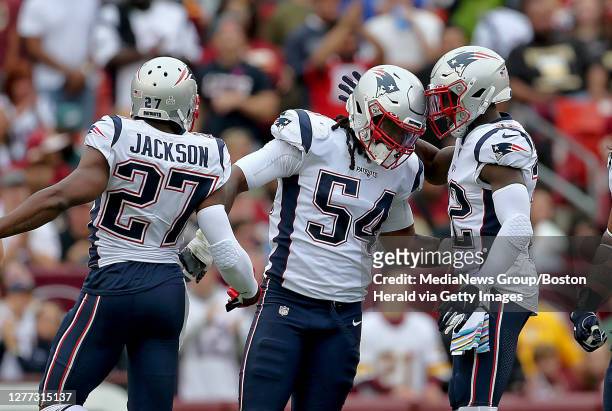 New England Patriots' Dont'a Hightower celebrates with J.C. Jackson and Devin McCourty after sacking Washington Redskins quarterback Colt McCoy for a...