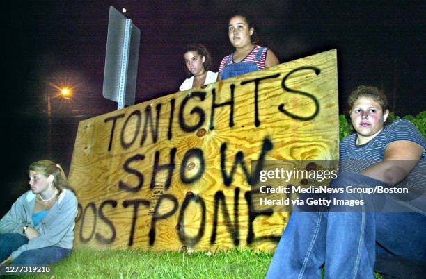 Mansfield, Ma.- Bummed out fans wait for their rides home at the Tweeter Center after waiting for hours for the Christina Aguilera concert which...