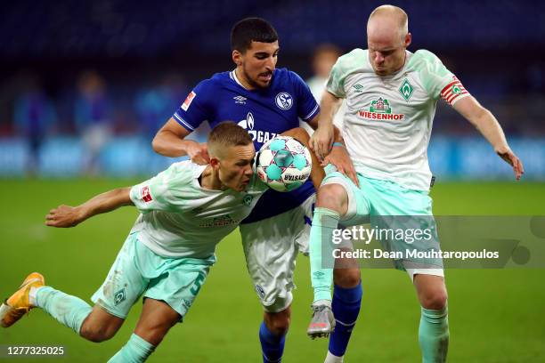 Nassim Boujellab of Schalke 04 battles for the ball with Ludwig Augustinsson and Davy Klaassen of Werder Bremen during the Bundesliga match between...