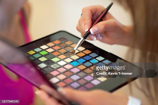 colorful makeup palette with brush and womans hand - pale complexion fotografías e imágenes de stock