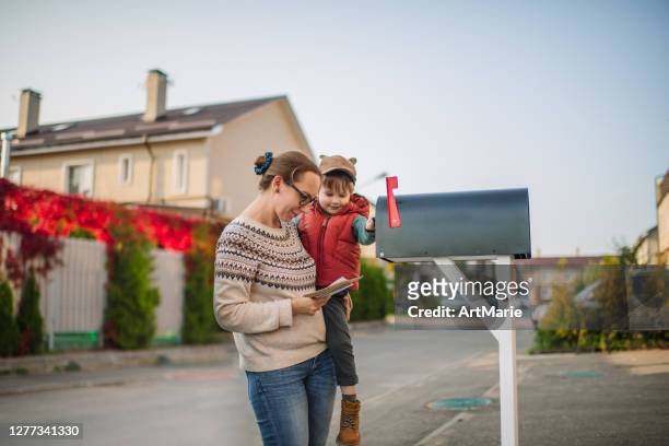 familj som skickar eller tar emot post med brevlåda nära hus - brevlåda bildbanksfoton och bilder