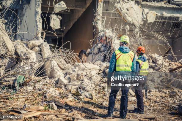 rescuer search trough ruins of building - earthquake house stock pictures, royalty-free photos & images