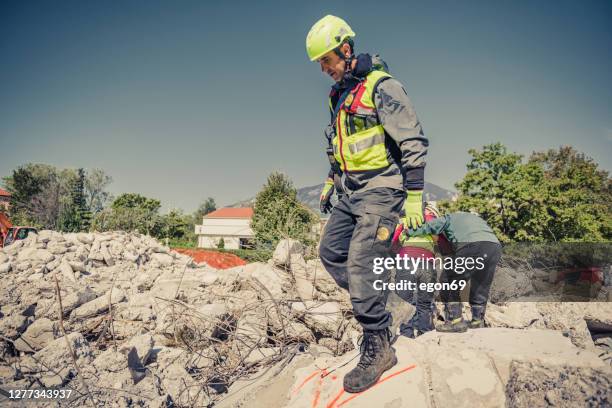 soccorritore ricerca attraverso rovine di edificio - fenomeno naturale foto e immagini stock