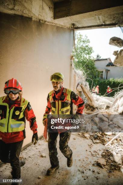 rescuer search trough ruins of building - disaster recovery stock pictures, royalty-free photos & images