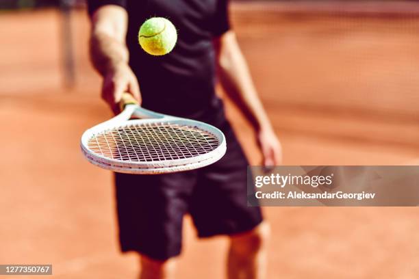 male tennis player bouncing ball on racket - balls bouncing stock pictures, royalty-free photos & images