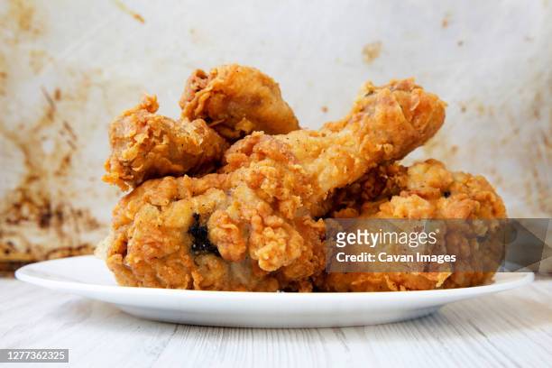 fried chicken drumsticks on a white round plate, closeup. side view. - fried chicken imagens e fotografias de stock