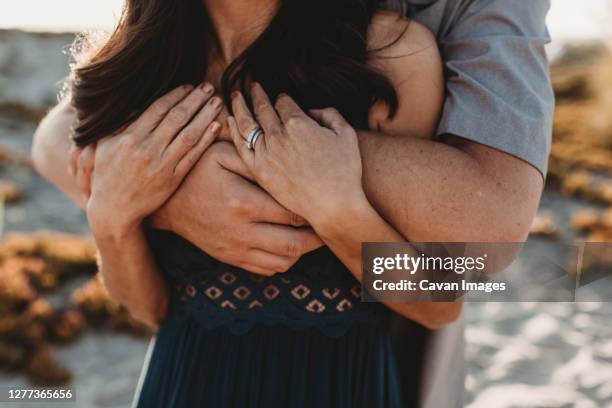 arms and hands detail image of husband embracing wife from behind - man touching shoulder stock pictures, royalty-free photos & images