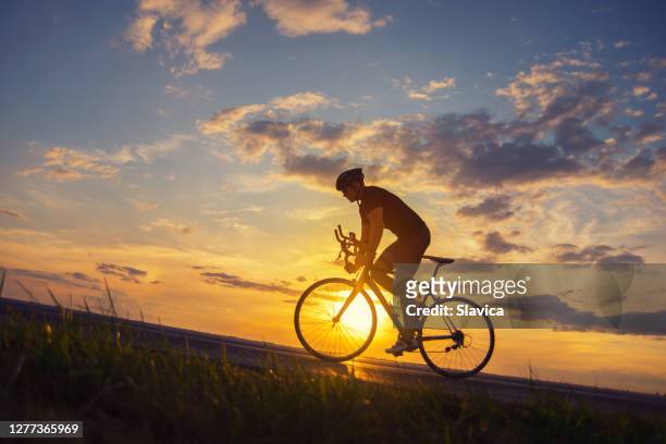 man cycling on the road - effort stock pictures, royalty-free photos & images