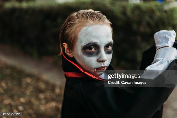 close up of young boy dressed in dracula costume on halloween - zombie face fotografías e imágenes de stock