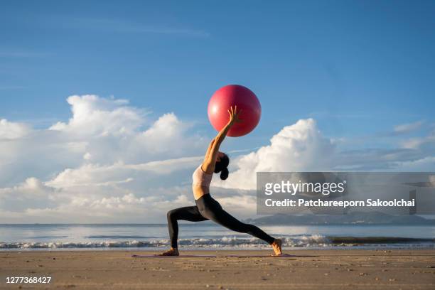 professional training yoga on the beach - gymnastikball stock-fotos und bilder