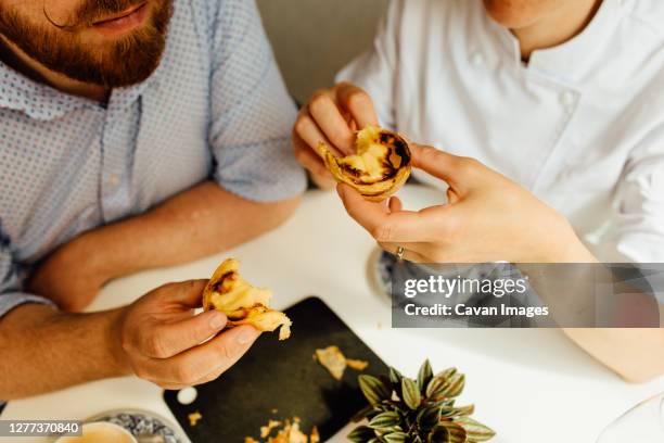 hands of couple eating dessert, portuguese custard tart - pastel de nata stock pictures, royalty-free photos & images