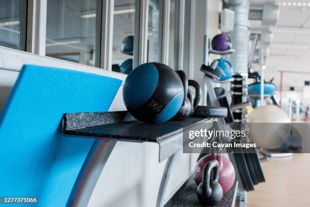 medicine weight balls on a stand at the gym full of fitness equipment - core strength stock pictures, royalty-free photos & images