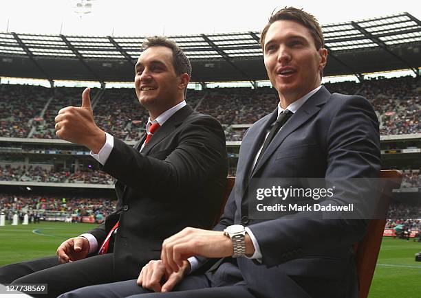 Retired players Daniel Bradshaw and Ryan Houlihan complete a lap of honour before the 2011 AFL Grand Final match between the Collingwood Magpies and...