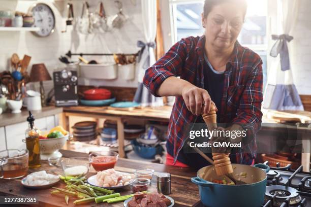 zubereitung cajun stil huhn, garnelen und wurst jambalaya in einem gusseisen topf - cajun food stock-fotos und bilder