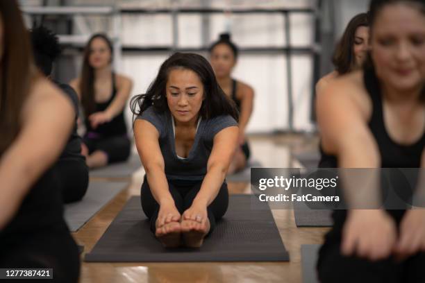 yoga class - touching toes stock pictures, royalty-free photos & images