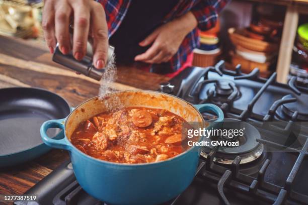 zubereitung von cajun style chicken, shrimps und sausage jambalaya in einem gusseisernen topf - cajun food stock-fotos und bilder