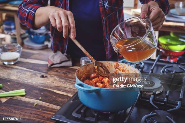 zubereitung cajun stil huhn, garnelen und wurst jambalaya in einem gusseisen topf - scharfe sauce stock-fotos und bilder