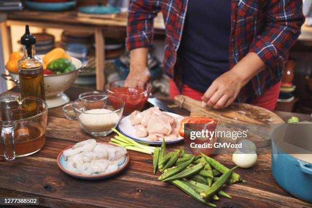 het bereiden van cajun style chicken, garnalen en worst jambalaya in een cast iron pot - ijzer stockfoto's en -beelden