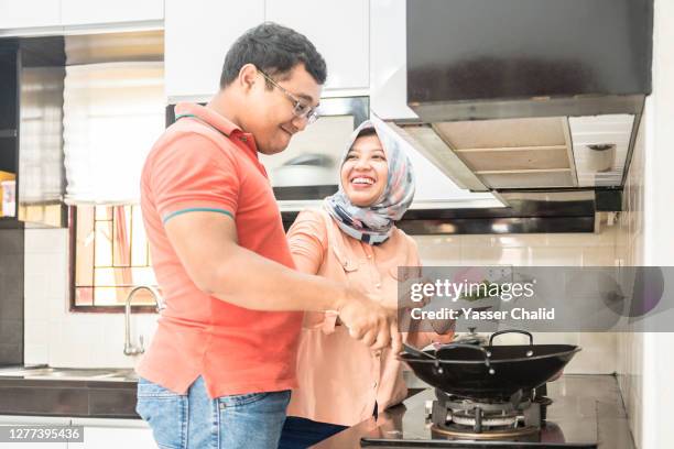 husband and wife cooking in kitchen - indonesian couple stock pictures, royalty-free photos & images