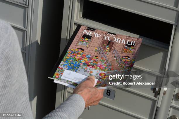 Woman retrieves a copy of The New Yorker magazine from her condominium cluster mailbox in Santa Fe, New Mexico.