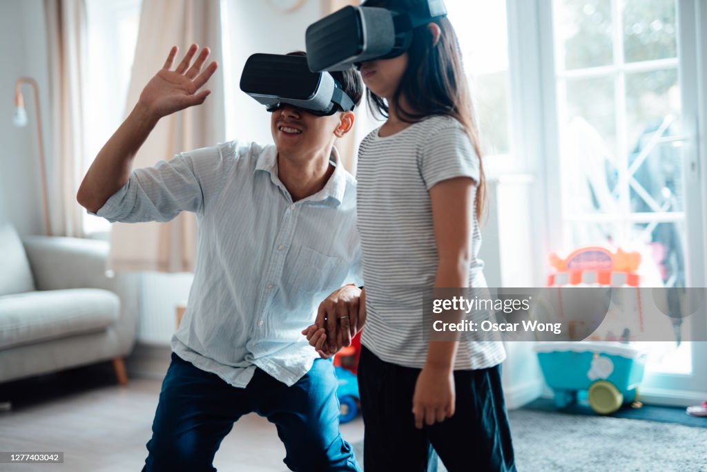 Father Using Virtual Reality Headset With His Daughter