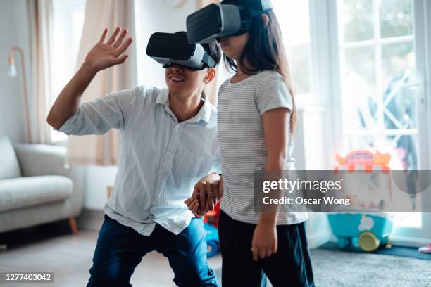 father using virtual reality headset with his daughter - vr headset kid stock pictures, royalty-free photos & images