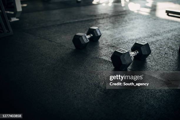 two dumbbells on the floor in gym - dumbbell stock pictures, royalty-free photos & images