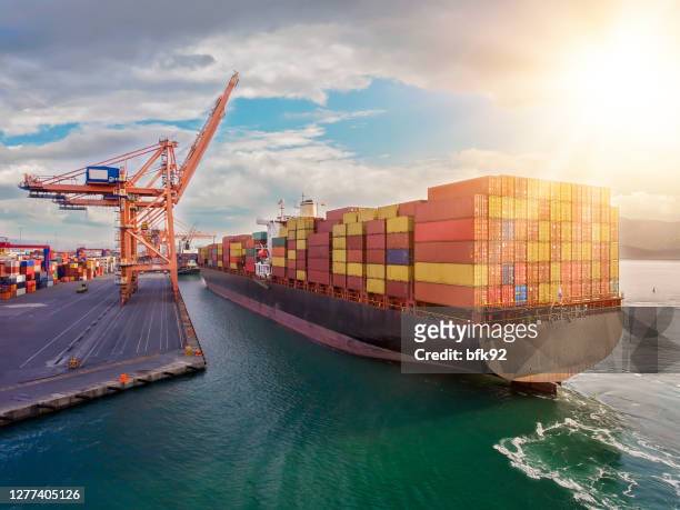 aerial view of industrial port with containers and container ship. - port stock pictures, royalty-free photos & images