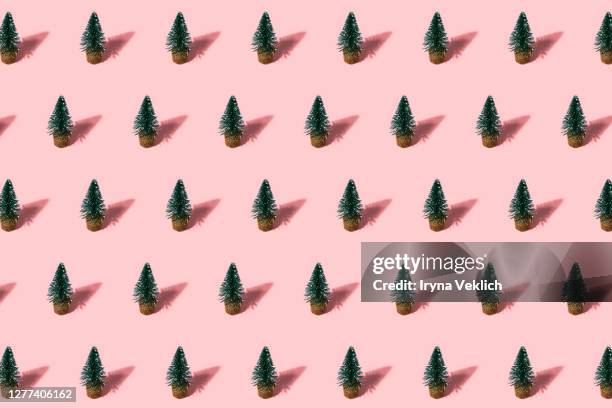 holiday pattern made of green christmas trees on pastel pink background. - green christmas designs stock-fotos und bilder