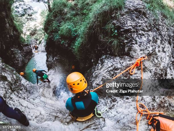 woman rappelling down the waterfall - canyoneering stock pictures, royalty-free photos & images