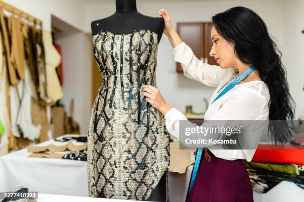 female fashion designer observing the dress on a dressmakers model to check for any irregularity - high fashion stock pictures, royalty-free photos & images
