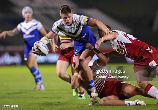 Morgan Knowles of St Helens is tackled by Ben Flower and Mitch Clark of Wigan Warriors during the Betfred Super League match between Wigan Warriors...