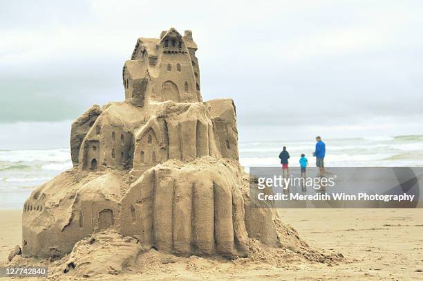 sandcastle and family at cannon beach in oregon - château de sable photos et images de collection