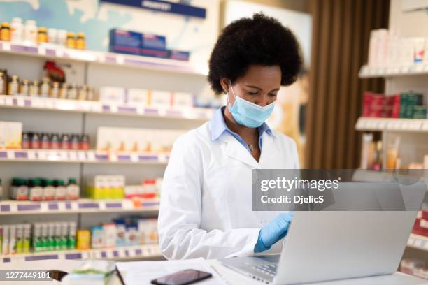 pharmacist with protection mask and gloves at work. - pharmacy mask stock pictures, royalty-free photos & images