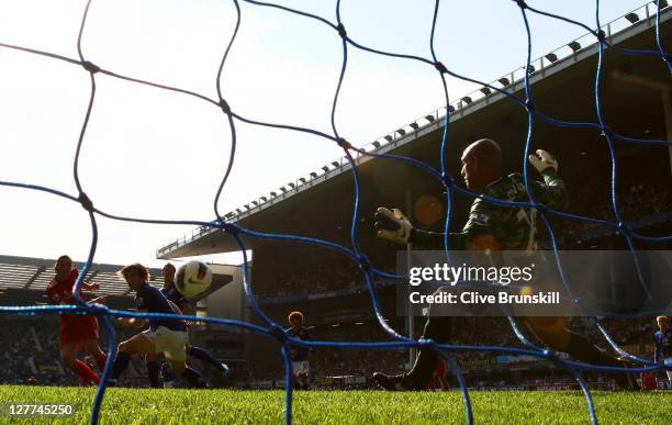 Andy Carroll of Liverpool scores the opening goal past Tim Howard of Everton during the Barclays Premier League match between Everton and Liverpool...