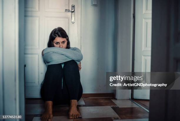 depressed woman desperately sitting on the floor in the darkness - suicide hotline stock pictures, royalty-free photos & images