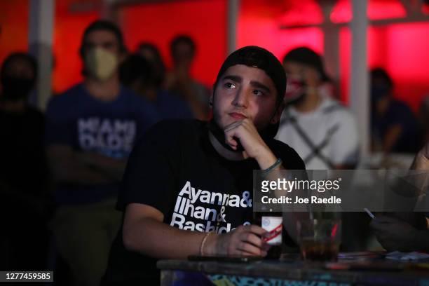 Pablo Arango and other people watch at Gramps bar a streaming broadcast of the first debate between President Donald Trump and Democratic...