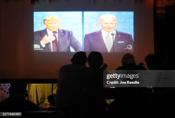 People watch at Gramps bar a television broadcasting the first debate between President Donald Trump and Democratic presidential nominee Joe Biden on...