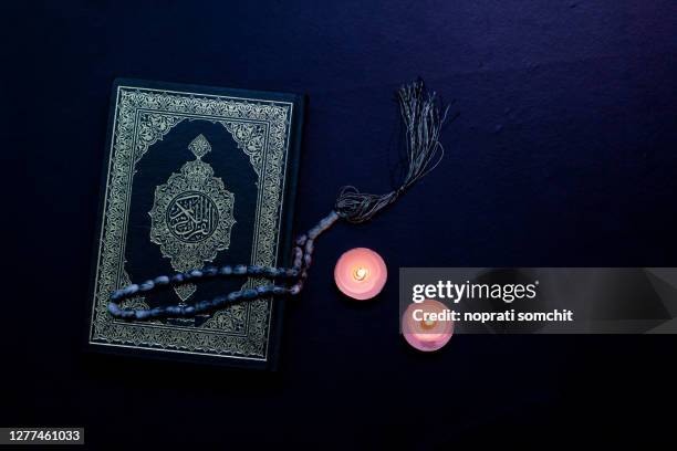 quran in the mosque at night and light from the candle - koran fotografías e imágenes de stock