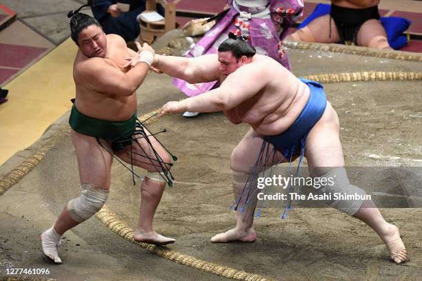 Aoiyama pushes Sadanoumi out of the ring to win on day twelve of the Grand Sumo Autumn Tournament at Ryogoku Kokugikan on September 24, 2020 in...