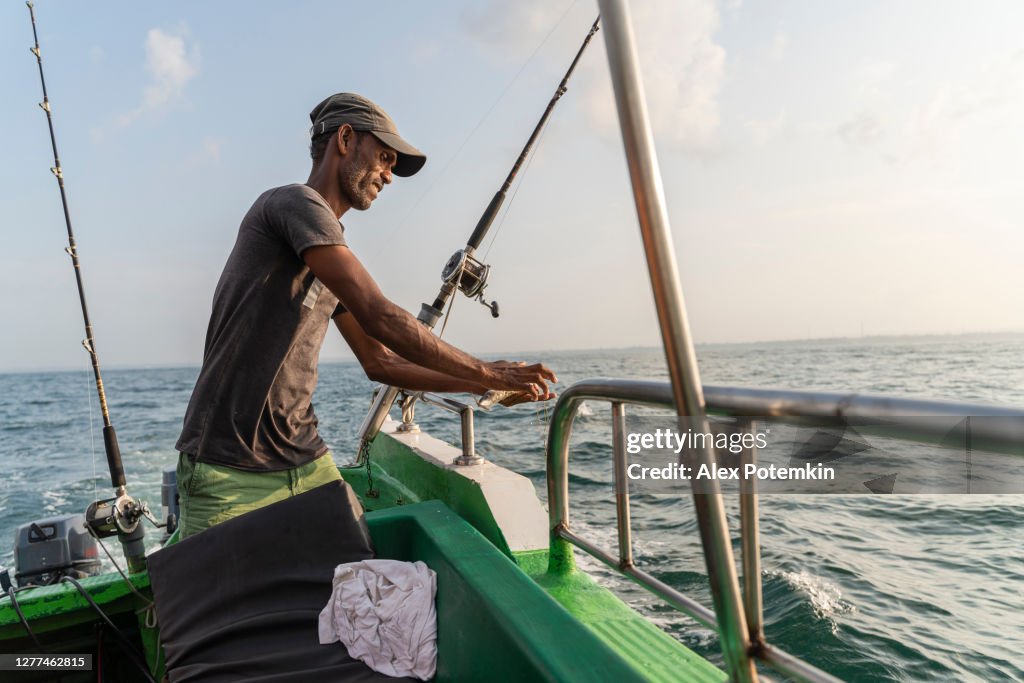 Fisherman Preparing The Fishing Equipment Attaching A Bait Aboard