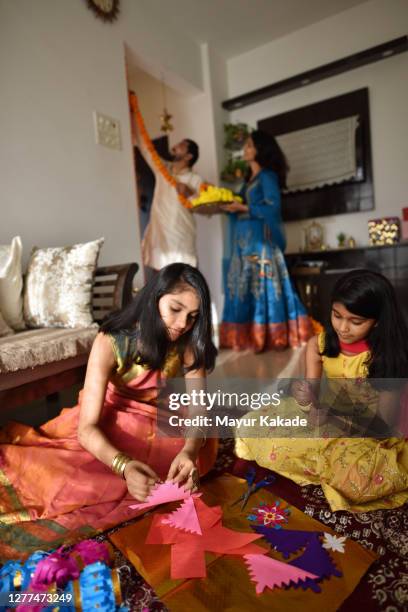 sisters making lanterns out of paper for diwali celebration - hindu festival preparation stock-fotos und bilder