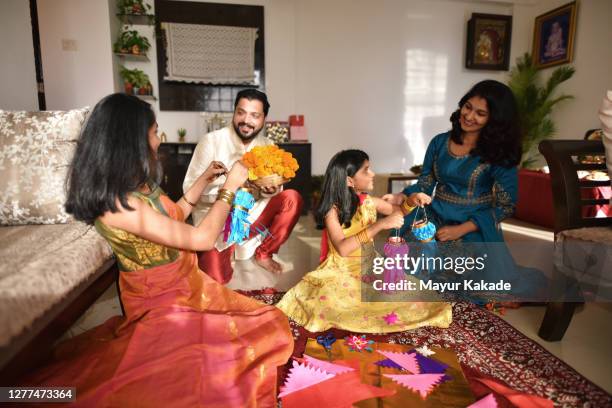 girls showing lanterns they made from paper to their parents - diwali family stock-fotos und bilder