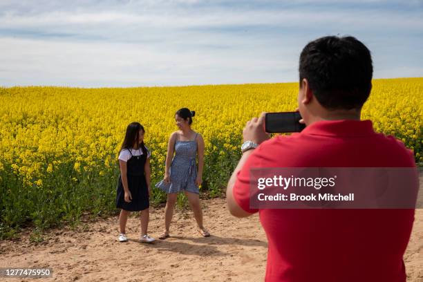 The Parjarillaga family from Western Sydney poses for photos amongst the canola fields near the town of Harden on September 30, 2020 in Harden,...