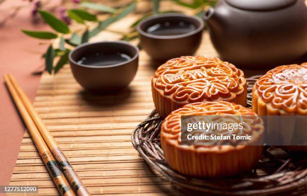 月餅の伝統的な中国のペストリーは、真秋の日のお祭りのためにお茶と一緒に提供 - 中秋節 ストックフォトと画像