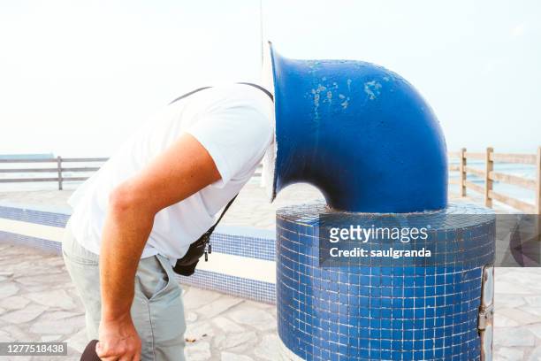 man with his head stuck in a trash can - nascondere la testa nella sabbia foto e immagini stock