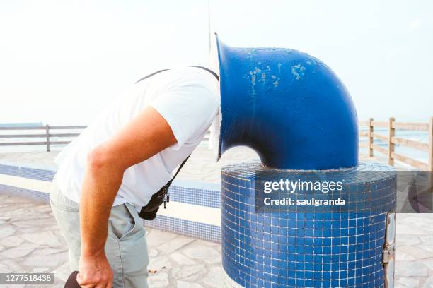 man with his head stuck in a trash can - 頭隠して尻隠さず ストックフォトと画像