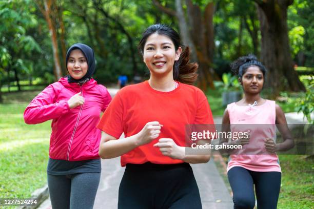 groep multi etnische vrouwen die in een openbaar park lopen - mixed race woman stockfoto's en -beelden